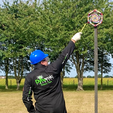 Standing sideways, at arm's length light the outermost end of the fuse and retire immediately to the stated distance on the firework label.
